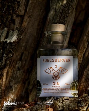 Bottle of Euelsberger Gin 45% vol 500 ml with geometric bird label on tree bark background