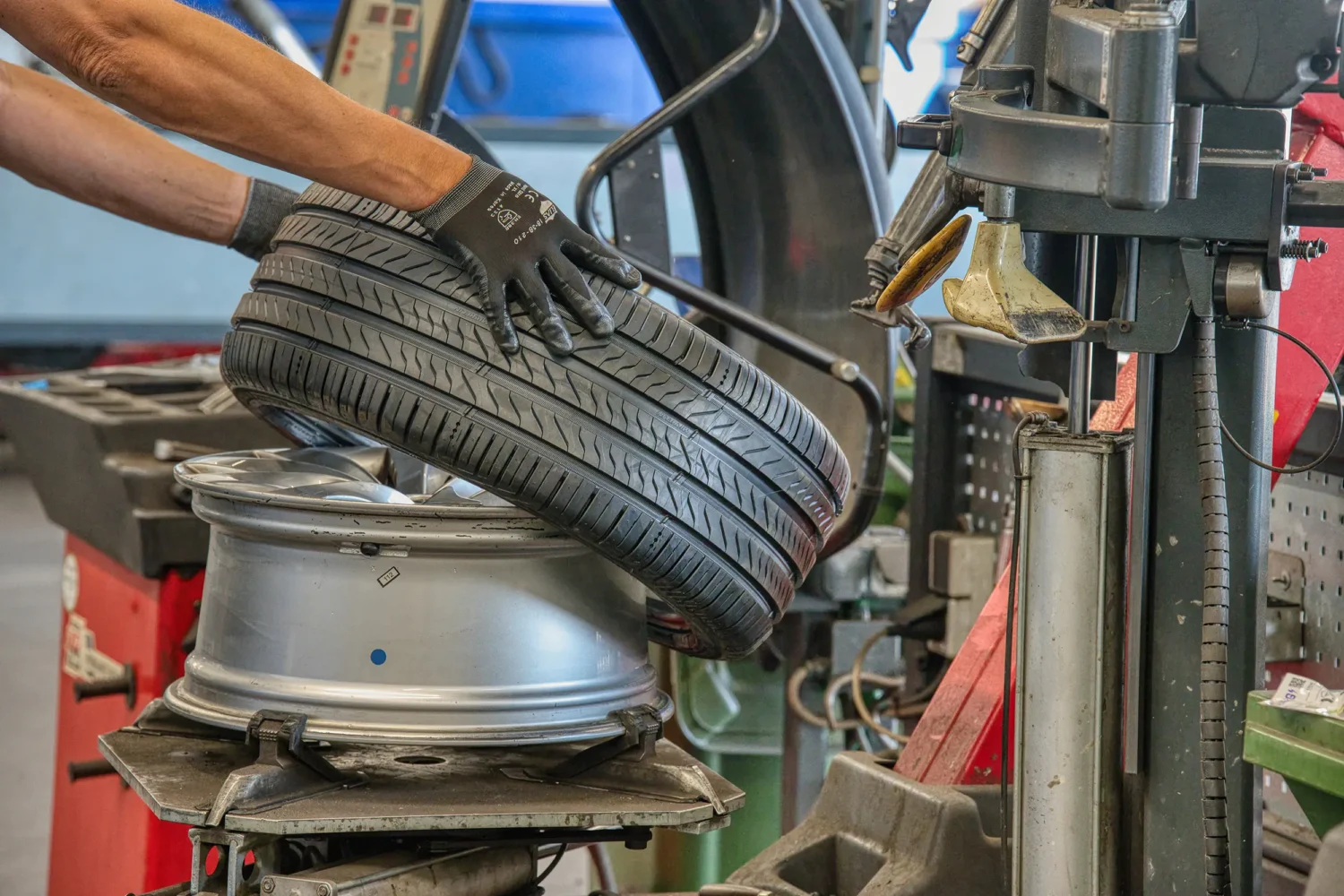 Professional close-up photography of tyre replacement in an automotive service centre.